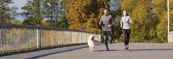 Couple jogging with dog